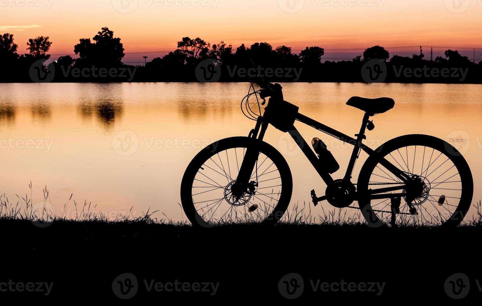 silueta bicicleta en puesta de sol antecedentes foto