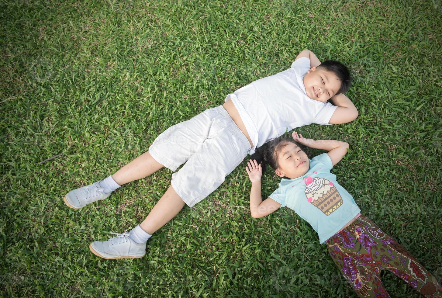 sonrisa niños mentira abajo en césped foto