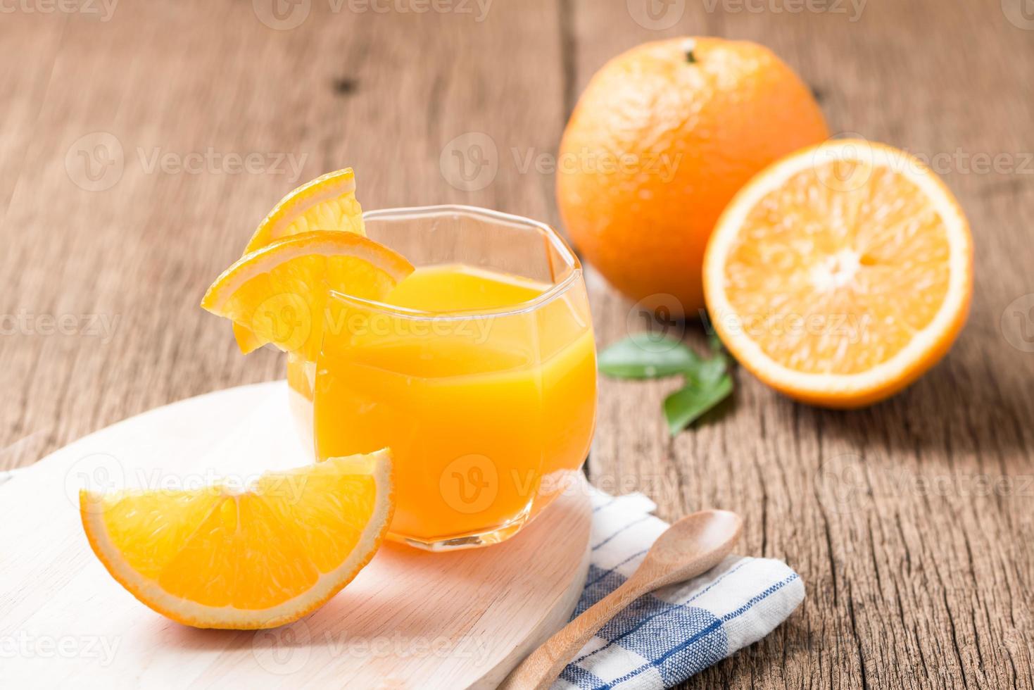 Glass of freshly pressed orange juice with sliced orange photo