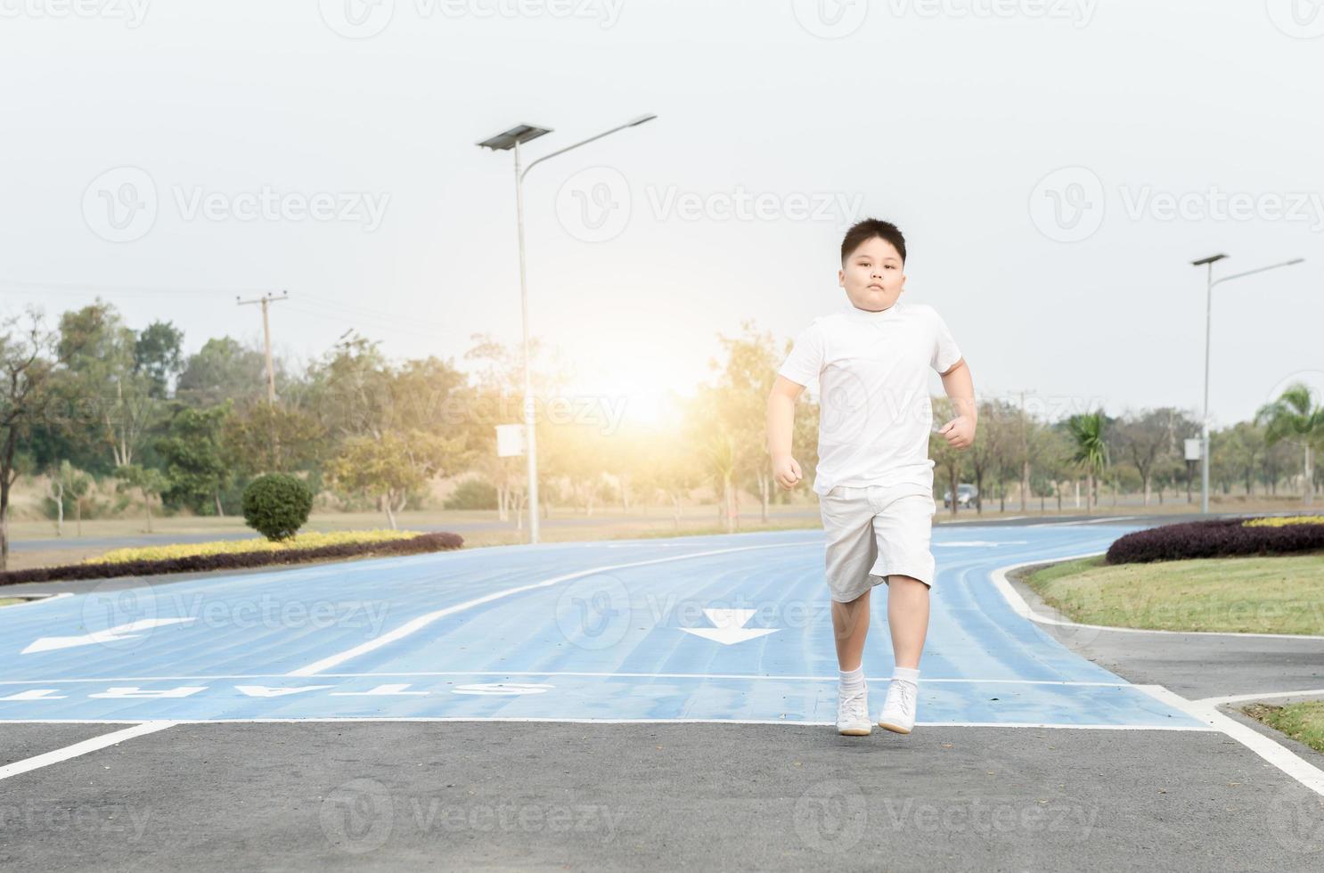 obeso grasa chico corriendo en parque foto