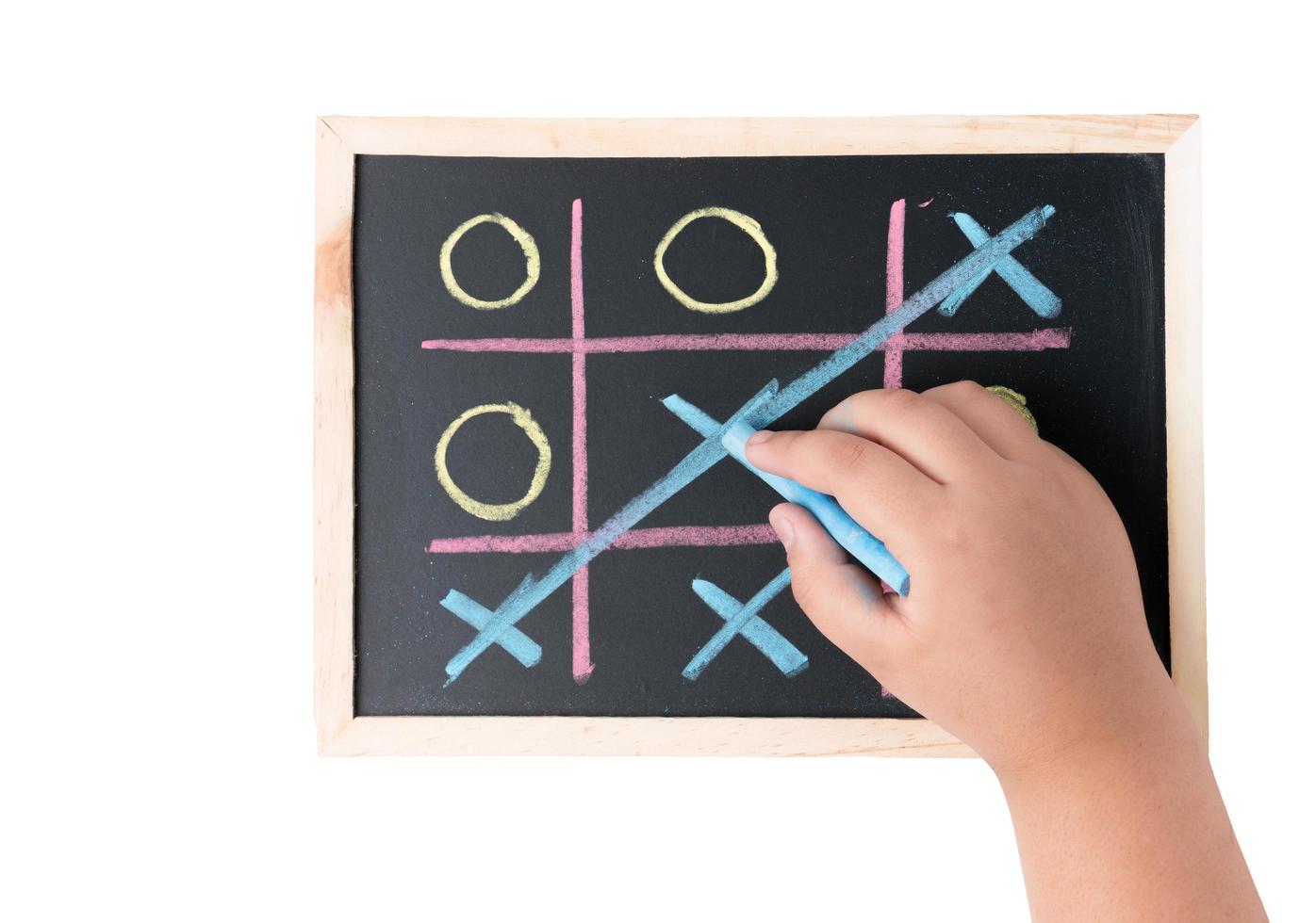 boy hand drawing a game of tic tac toe on a black chalkboard photo