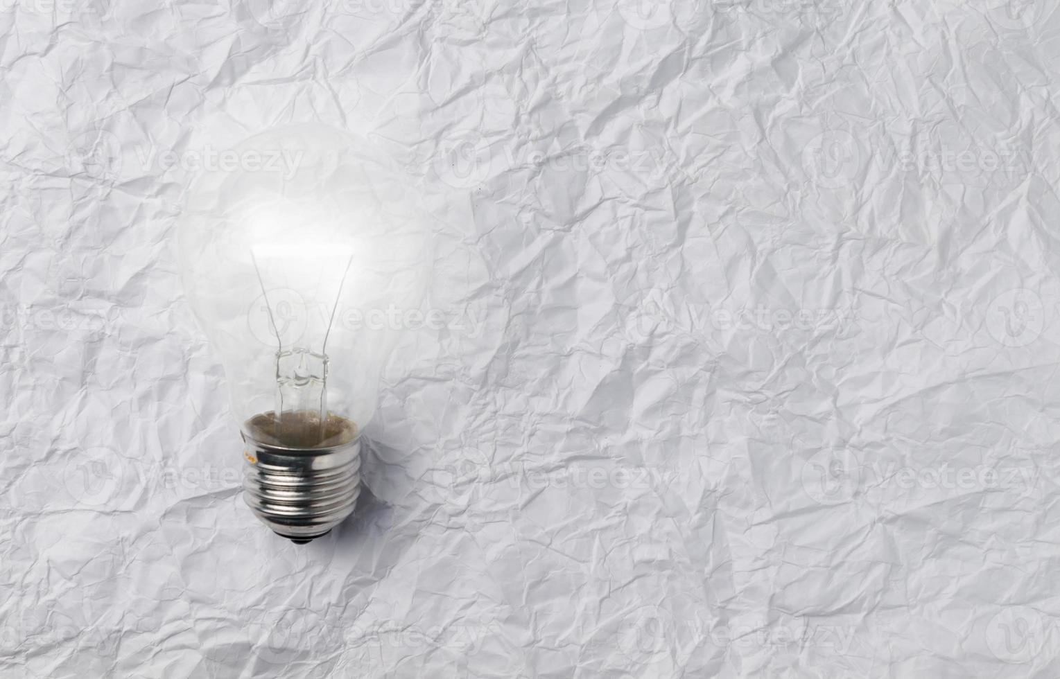 bulb light on crumpled paper background photo