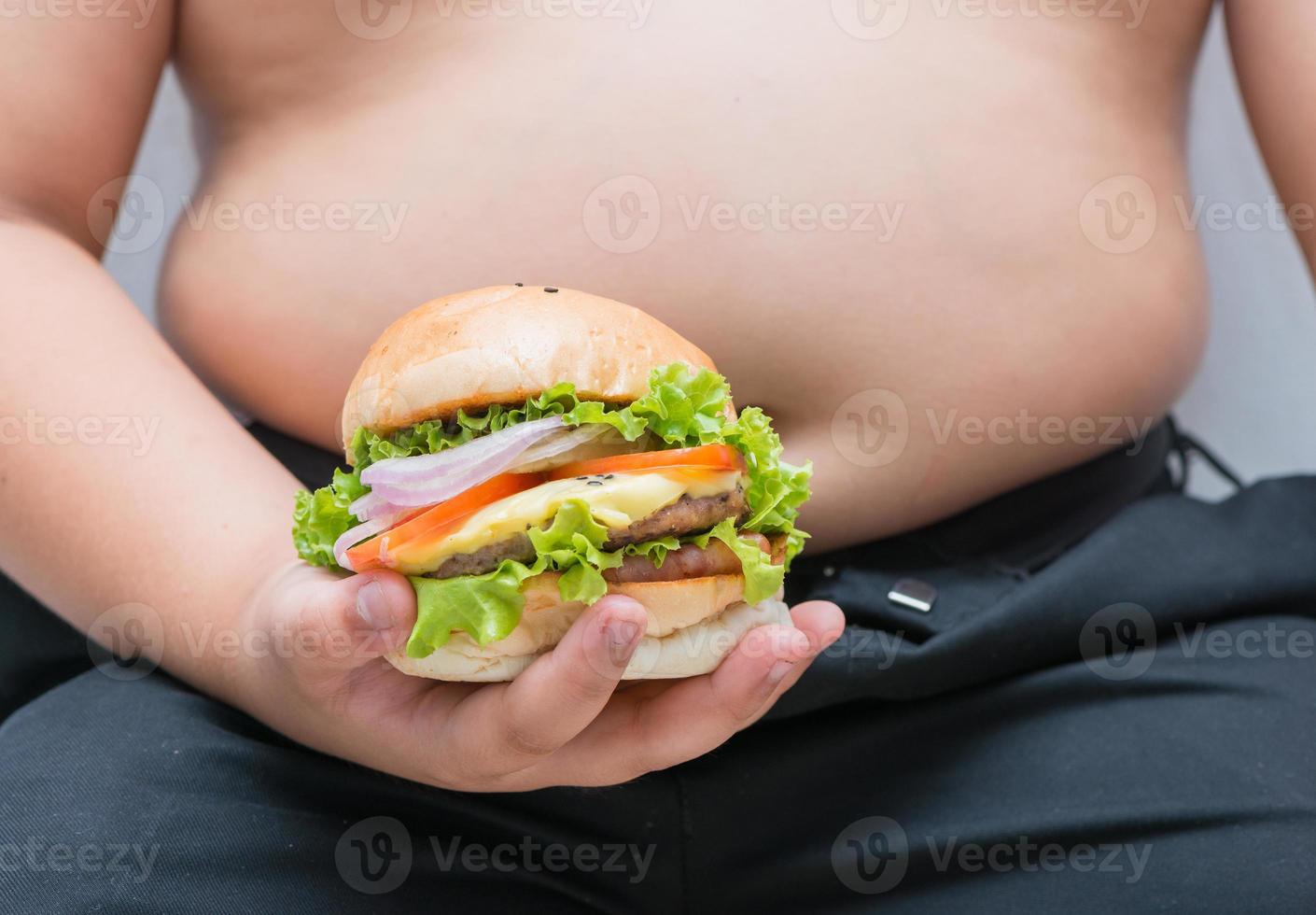 pork cheese Hamburger in obese fat boy hand photo