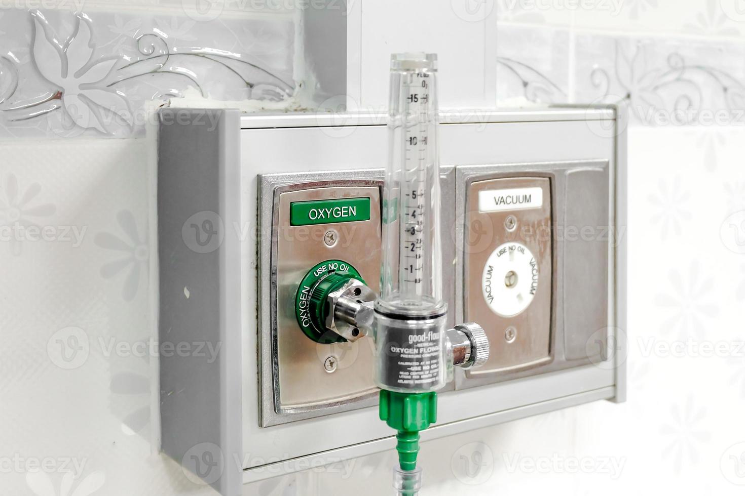 Oxygen flow meter plugged in the green outlet on  hospital wall, Medical equipment. photo