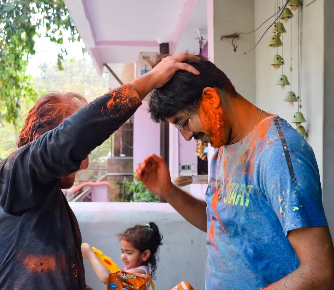 Delhi, India - February 26 2023 - Indian family people playing colours on Holi festival, holding different colours, Holi festival celebrations in Delhi, India photo