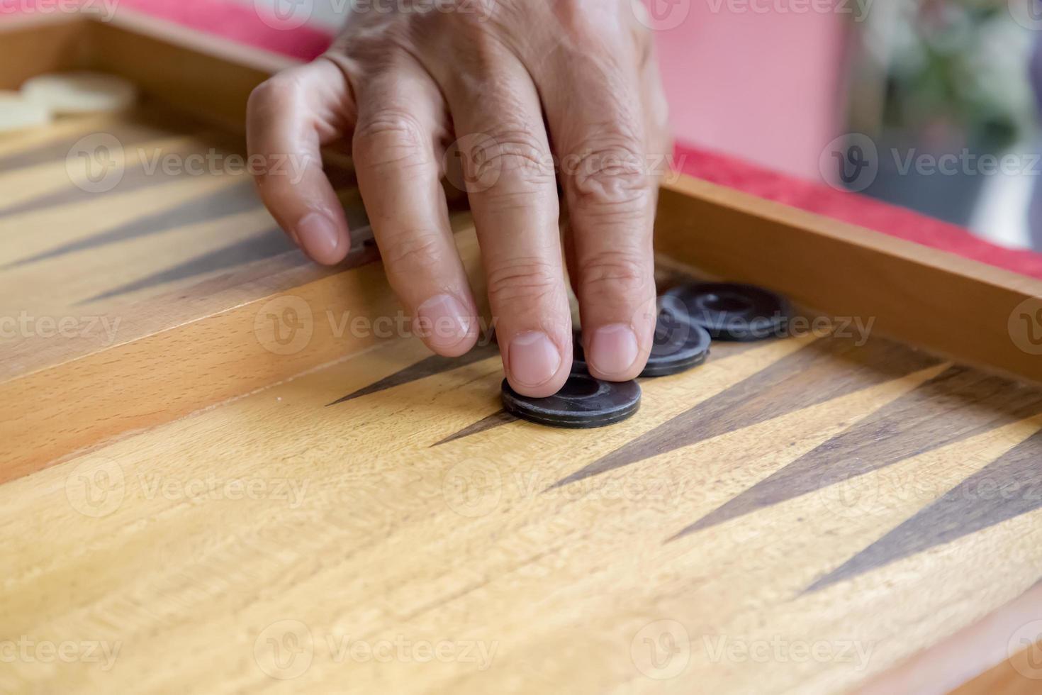 a man moves a pool in a backgammon game photo