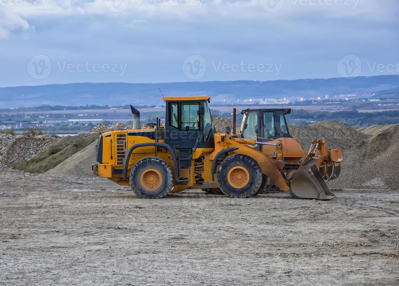 bulldozer and excavator in a construction site after work photo