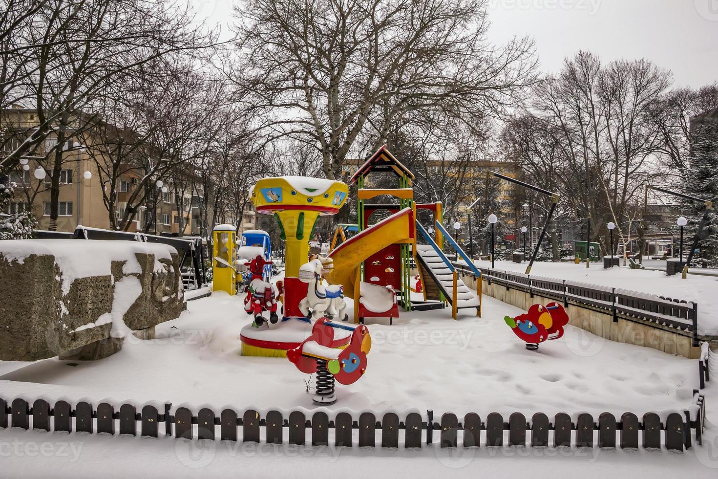 colorful children playground covered snow at the city park photo