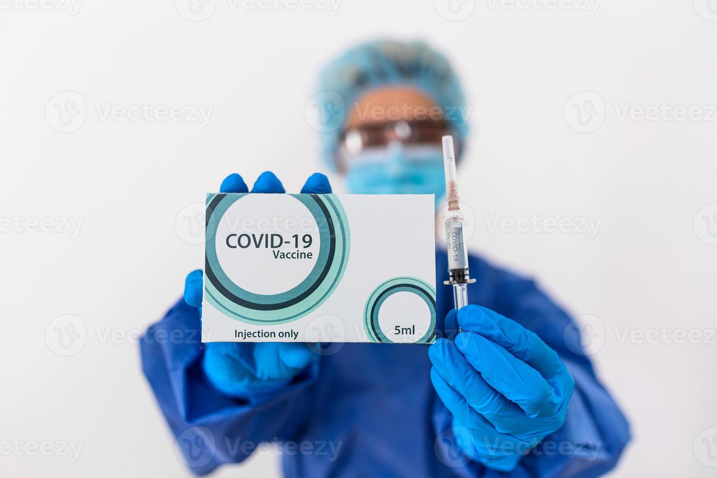 Doctor holds COVID 19 vaccine and syringe in her hand, Vaccine it use for prevention, immunization and treatment from COVID-19. photo