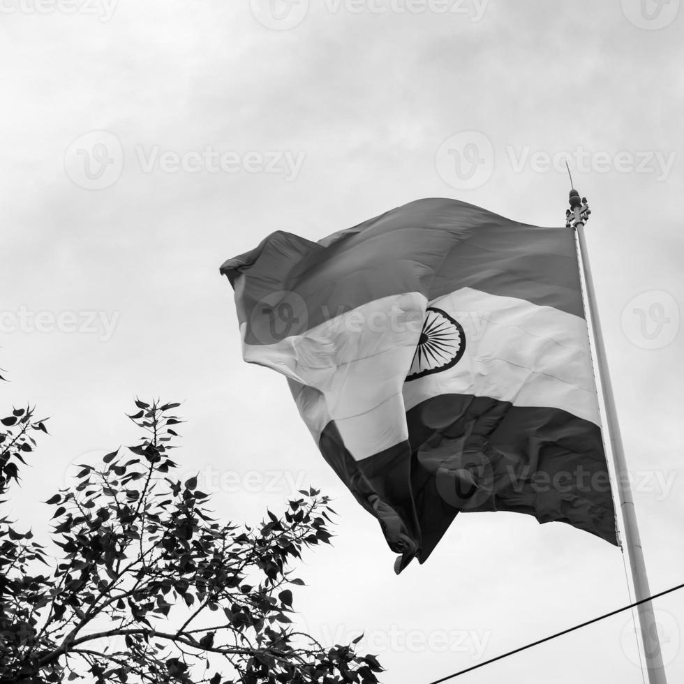 India flag flying high at Connaught Place with pride in blue sky, India flag fluttering, Indian Flag on Independence Day and Republic Day of India, tilt up shot, Waving Indian flag, Har Ghar Tiranga photo