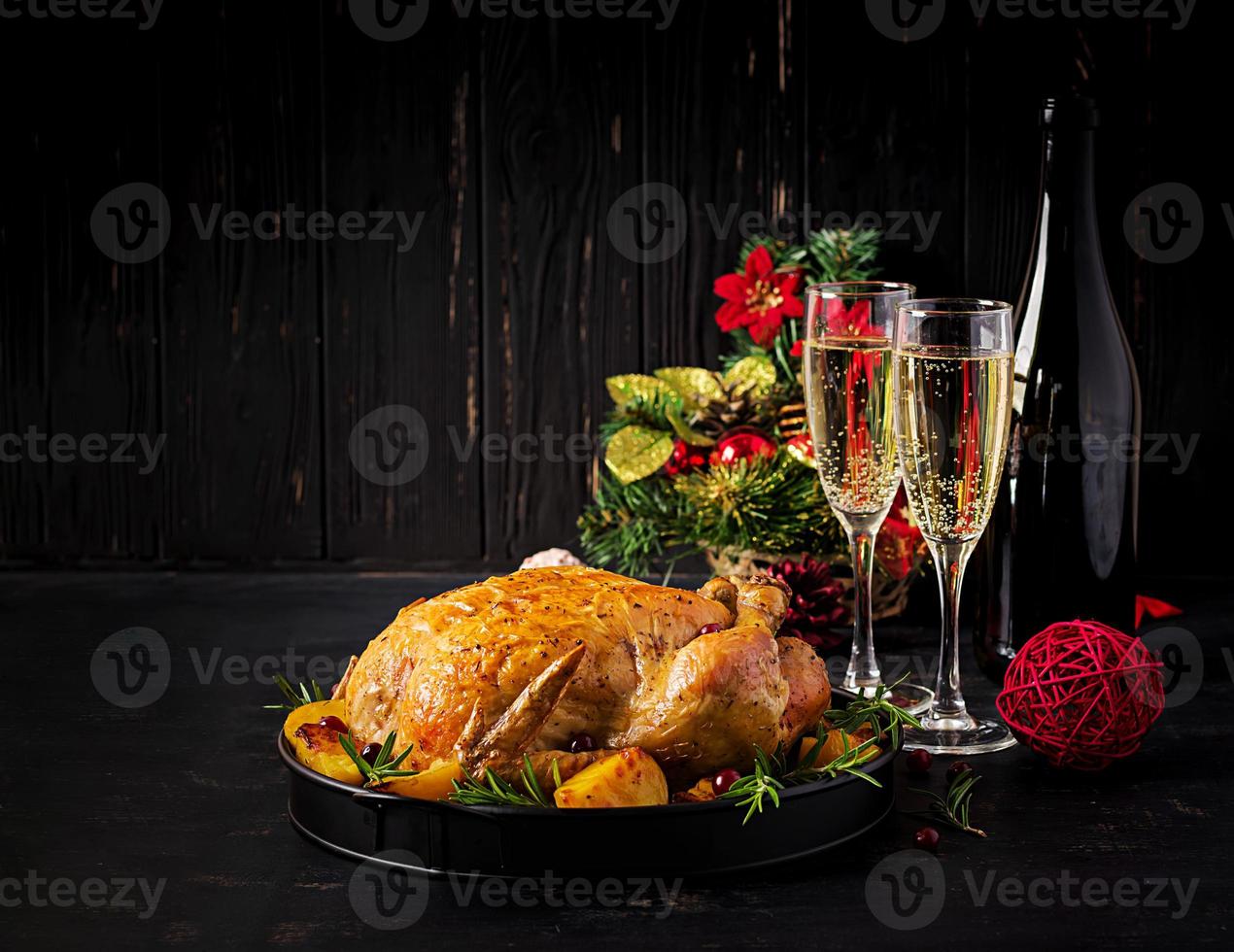 Baked turkey or chicken. The Christmas table is served with a turkey, decorated with bright tinsel. Fried chicken, table. Christmas dinner. photo