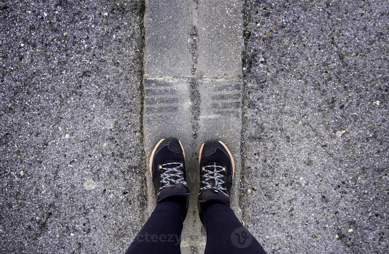 Woman's feet on the asphalt photo