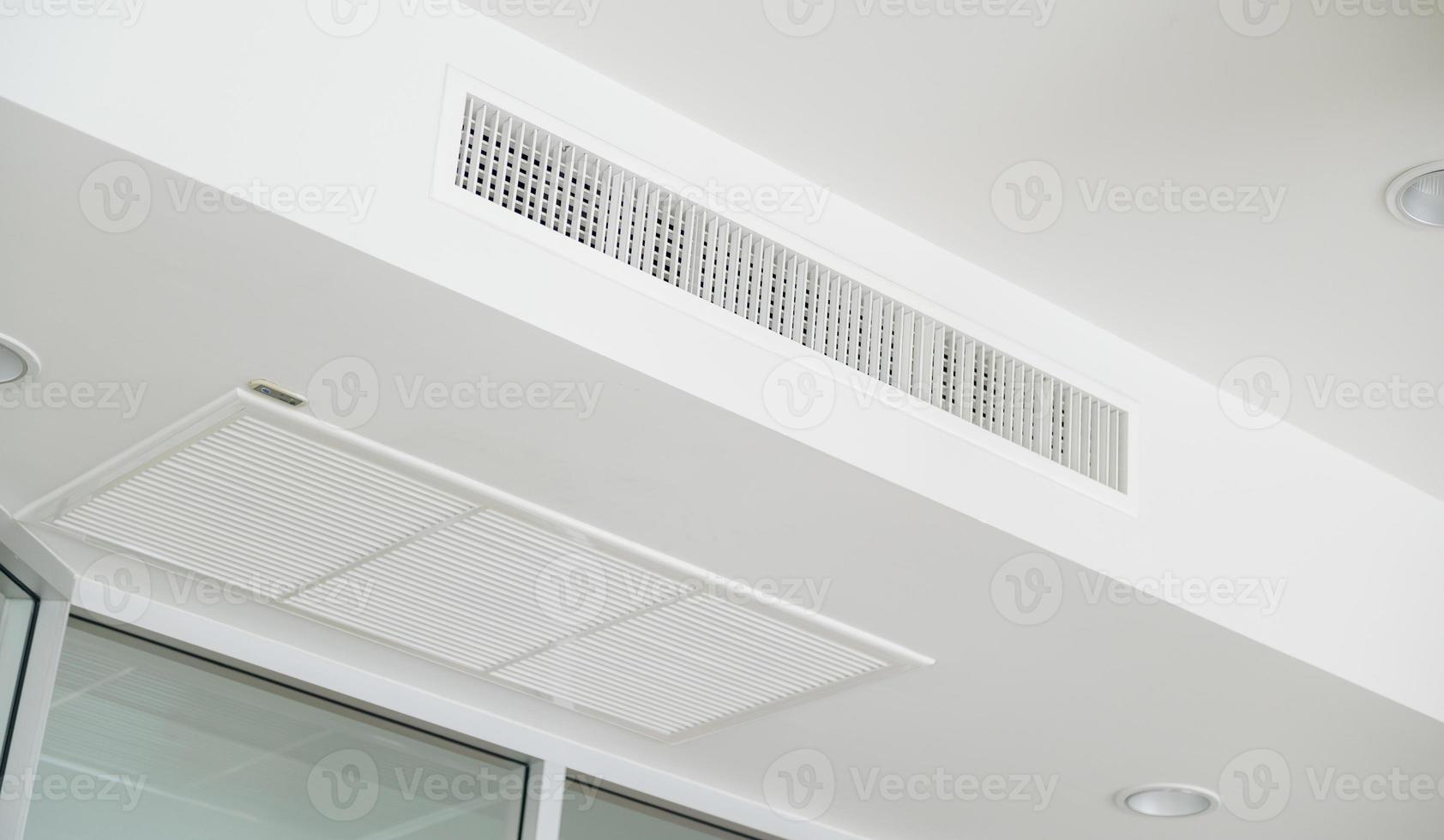 Ceiling mounted cassette type air conditioner and modern lamp light on white ceiling. duct air conditioner for home or office photo