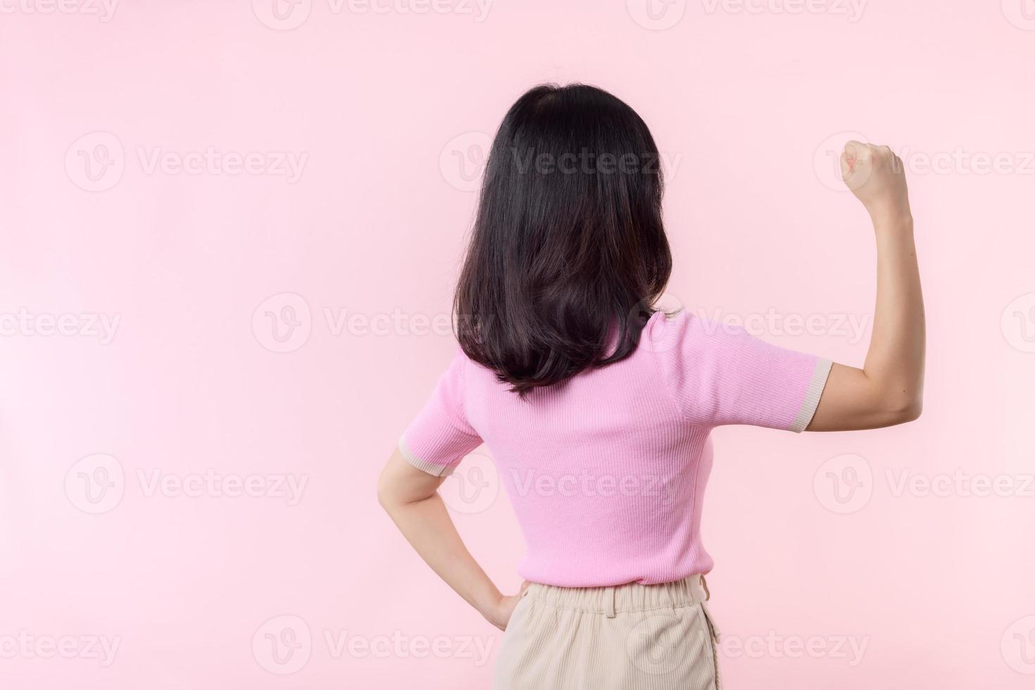 retrato espalda de mujer orgulloso y confidente demostración fuerte músculo fuerza brazos flexionado posando, siente acerca de su éxito logro. mujer empoderamiento, igualdad, sano fuerza y valor concepto foto