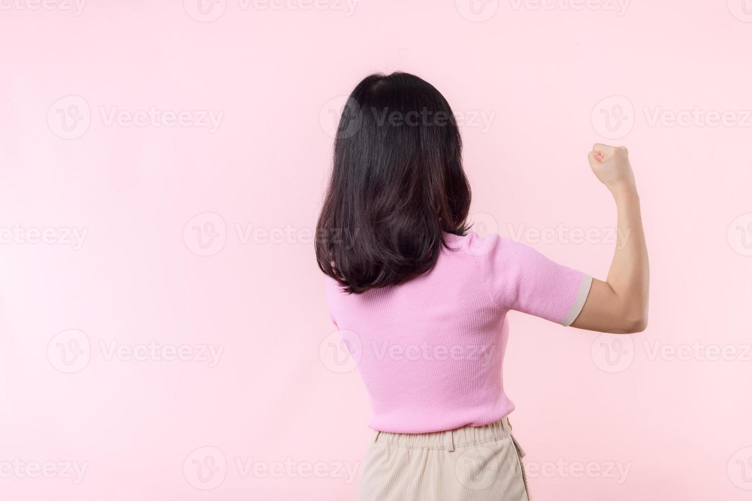 Portrait back of woman proud and confident showing strong muscle strength arms flexed posing, feels about her success achievement. Women empowerment, equality, healthy strength and courage concept photo