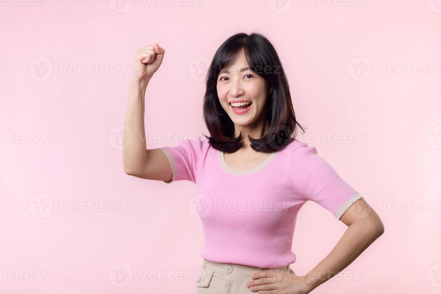 retrato joven asiático mujer orgulloso y confidente demostración fuerte músculo fuerza brazos flexionado posando, siente acerca de su éxito logro. mujer empoderamiento, igualdad, sano fuerza y valor concepto foto