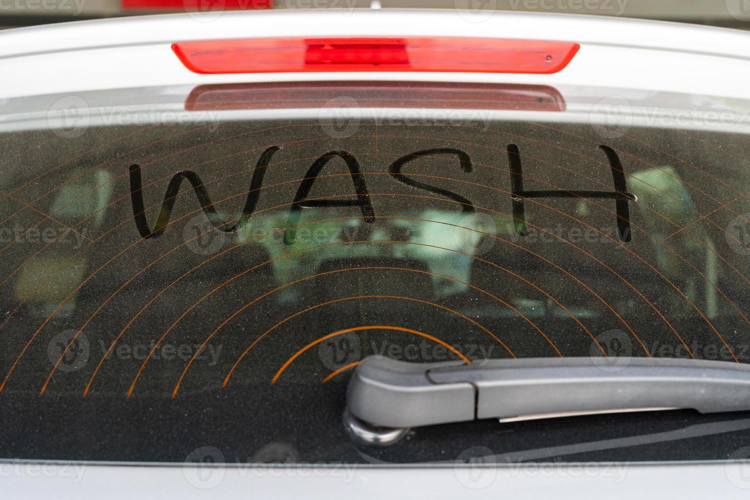 Dirty rear window of the car and inscription Wash. Wash Text on Dirty Car. photo