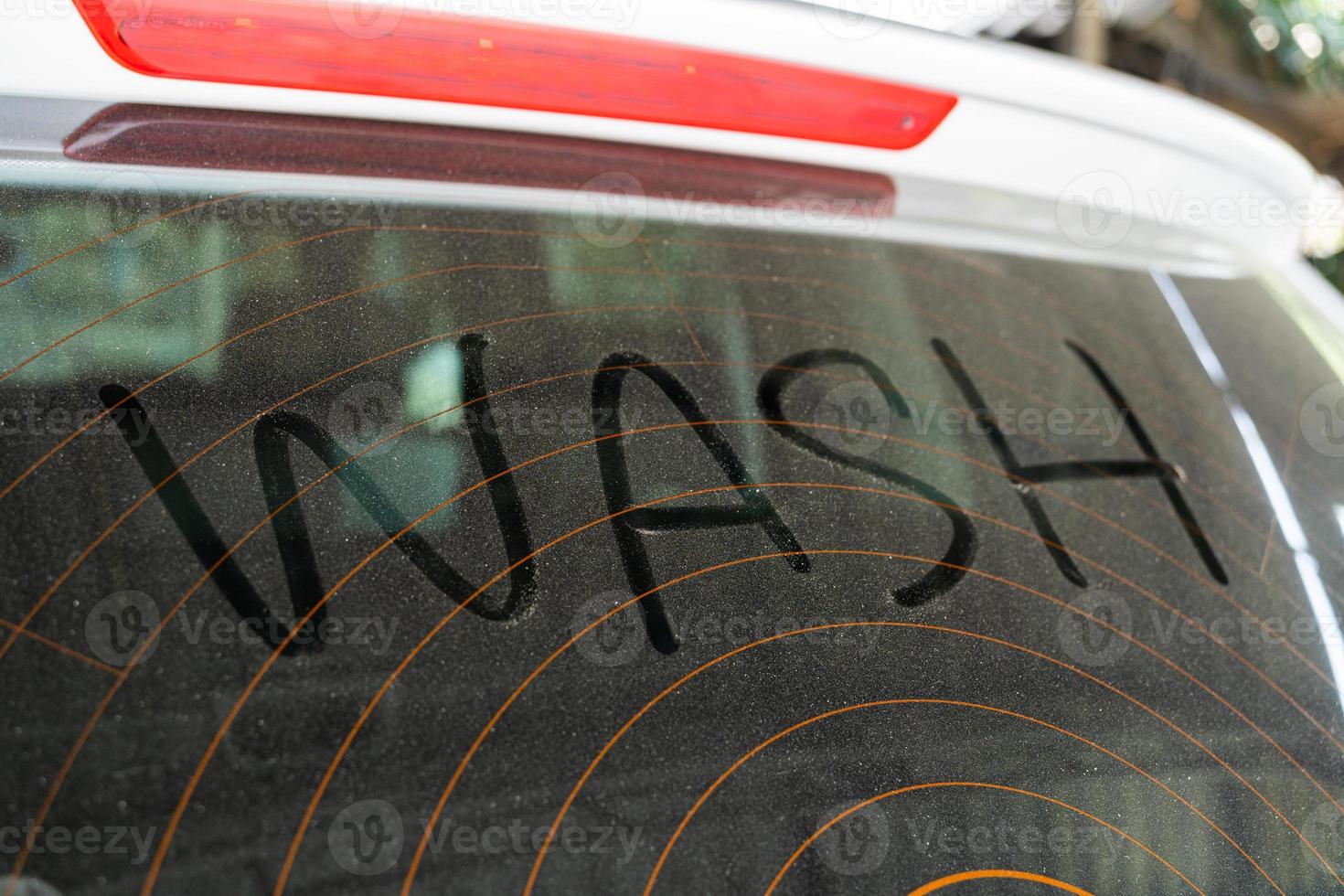 Dirty rear window of the car and inscription Wash. Wash Text on Dirty Car. photo