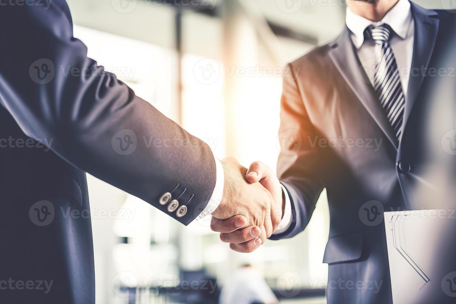 Businessman shaking hands after signing off on a meeting with partners, setting goals, and planning the way to success. Collaborative teamwork photo