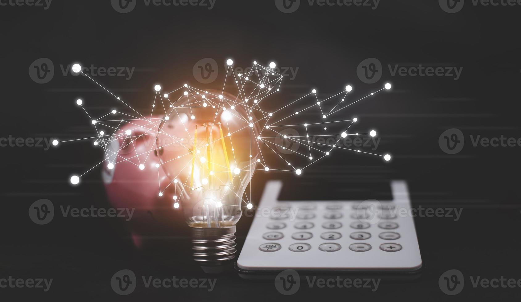 Thinking and creative concept, calculator with piggy bank and light bulb style bokeh vintage dark background,Concept The idea of reading books, knowledge, and searching for new ideas. photo