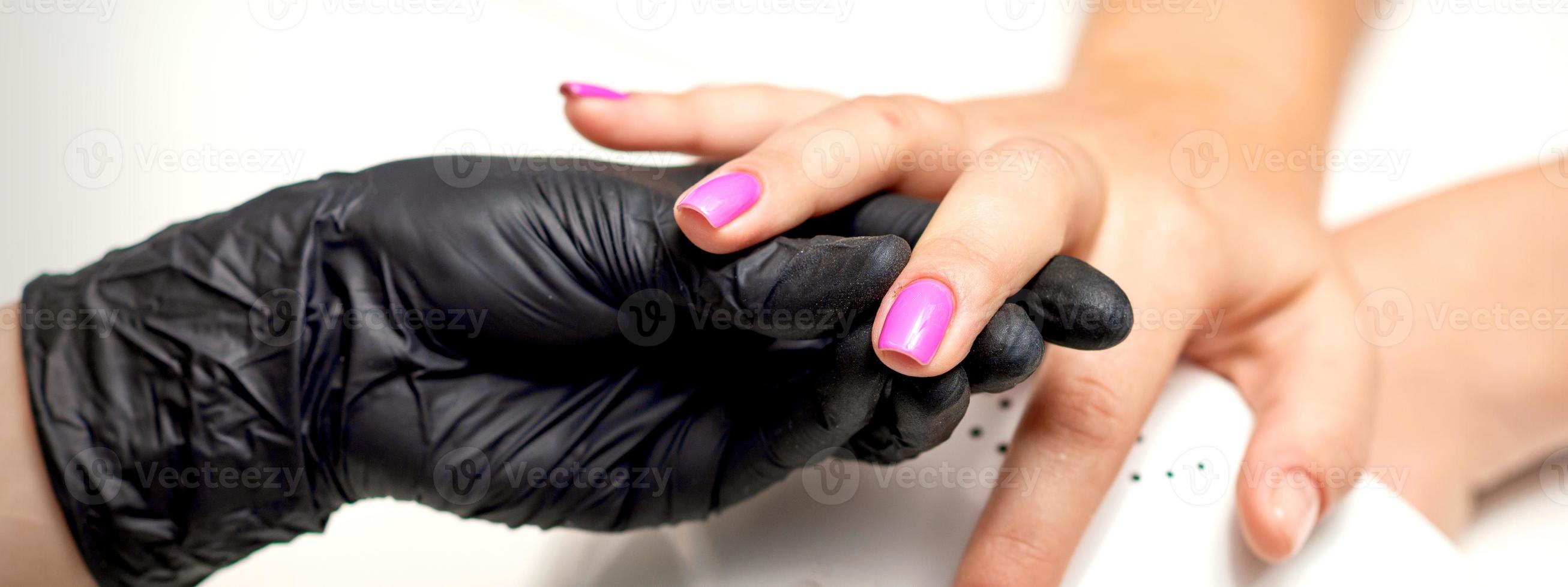 Finger with purple nail polish photo