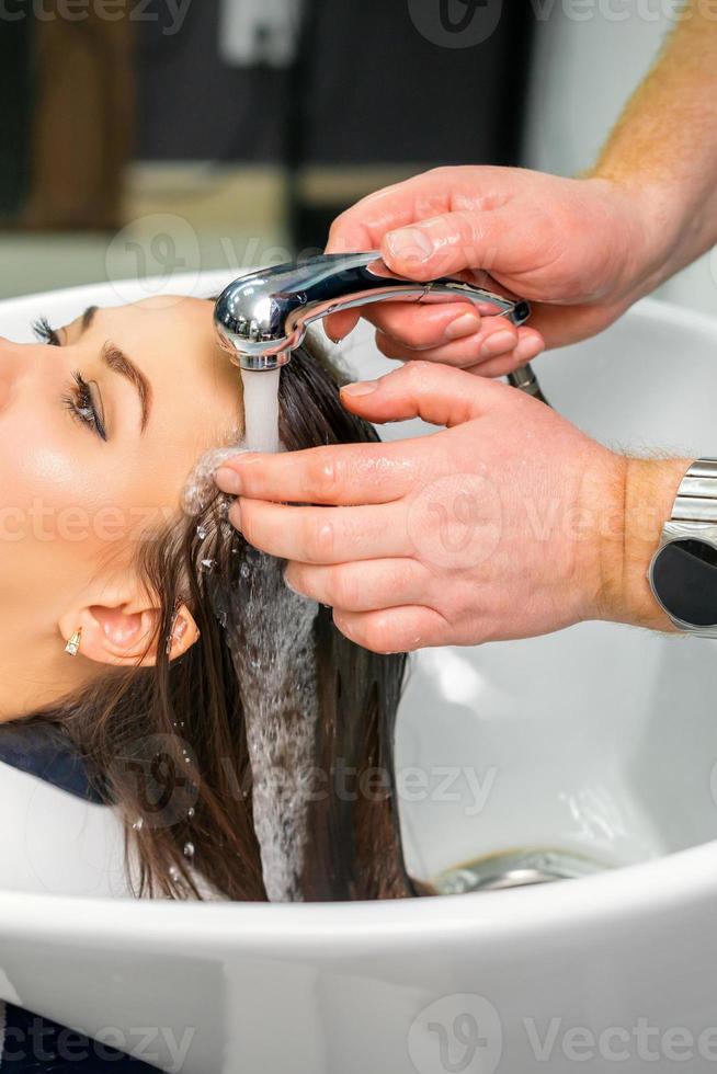 Hairdresser begins to wash hair photo