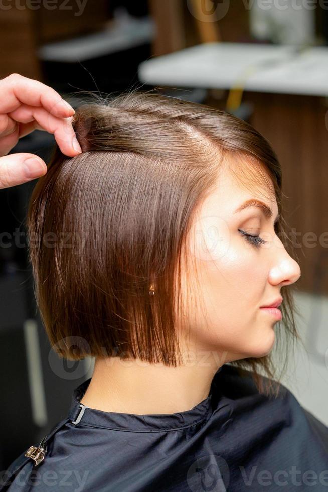 Hairdresser is straightening the hair photo