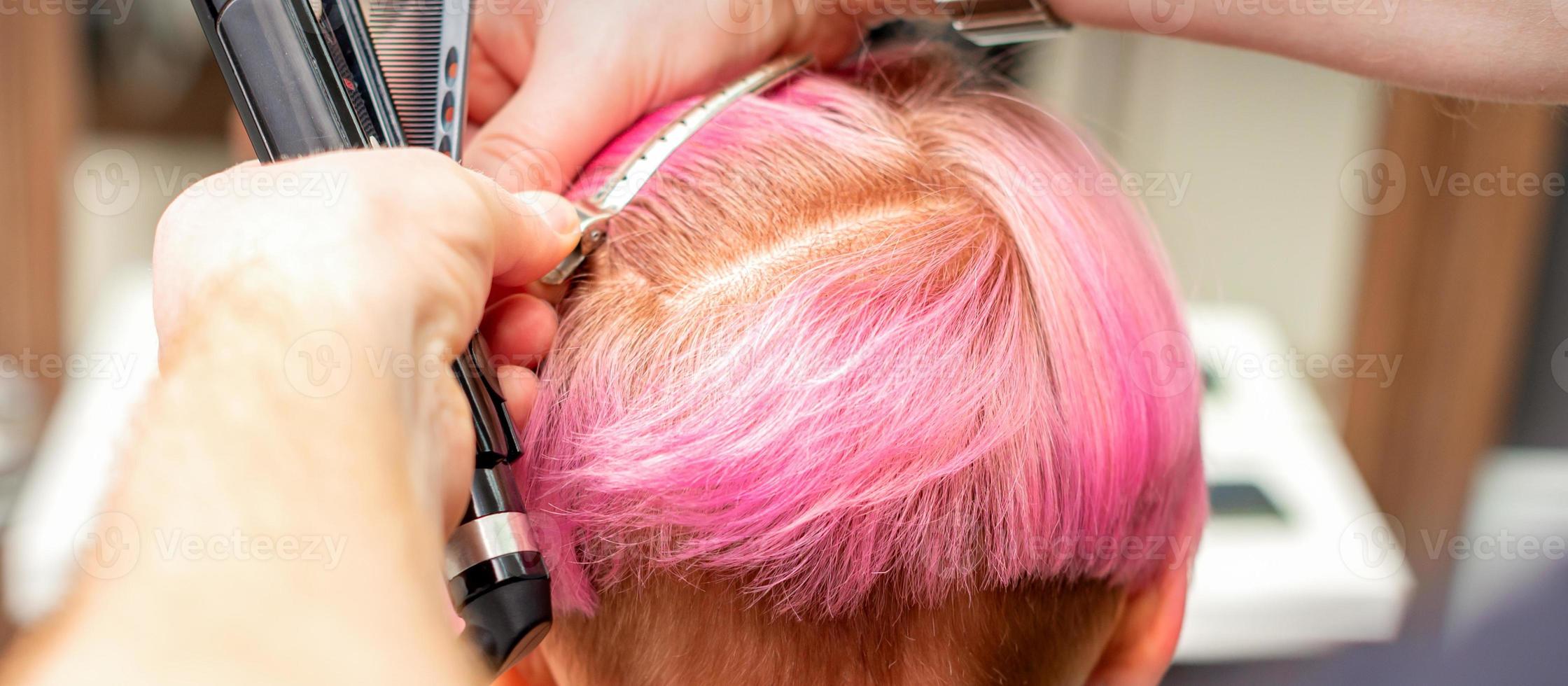 Hairdresser pinches hair with clip photo