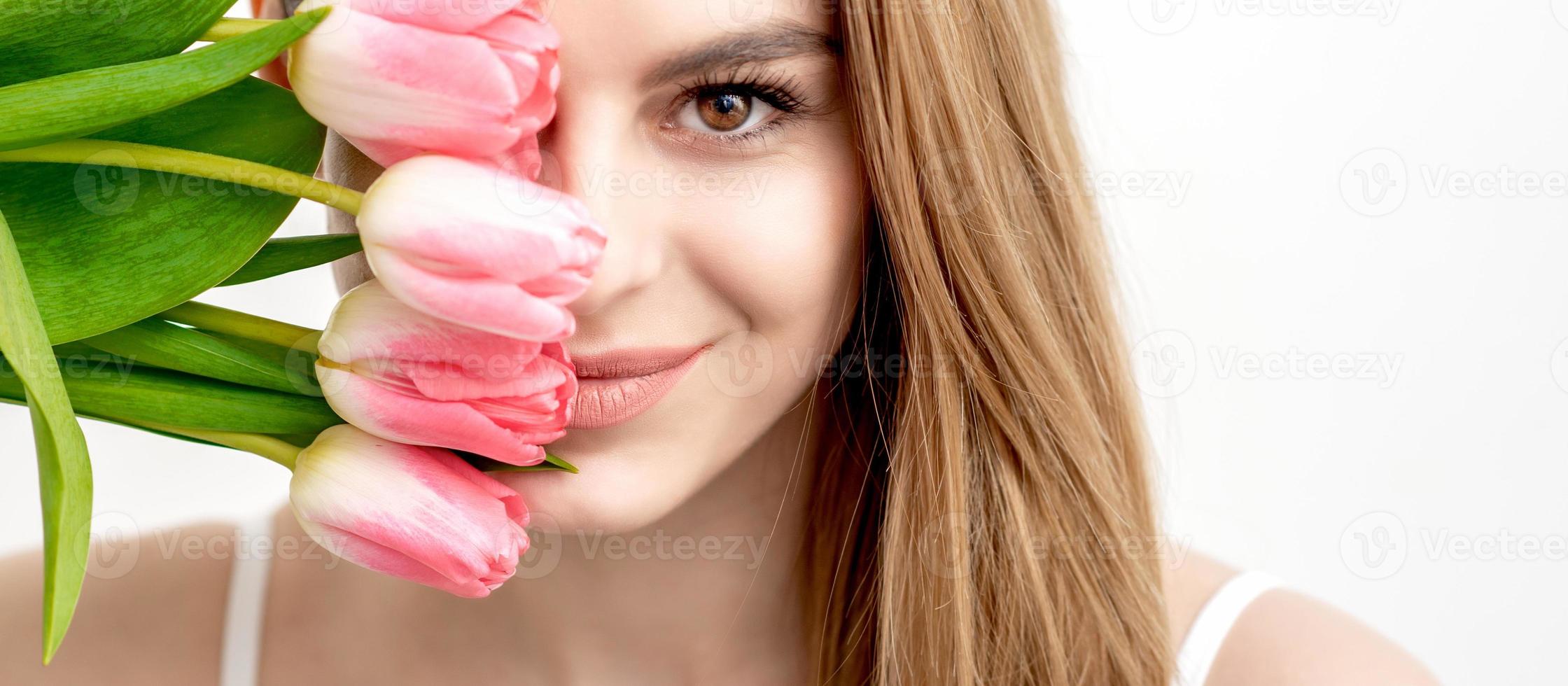 Portrait of woman with pink tulips photo