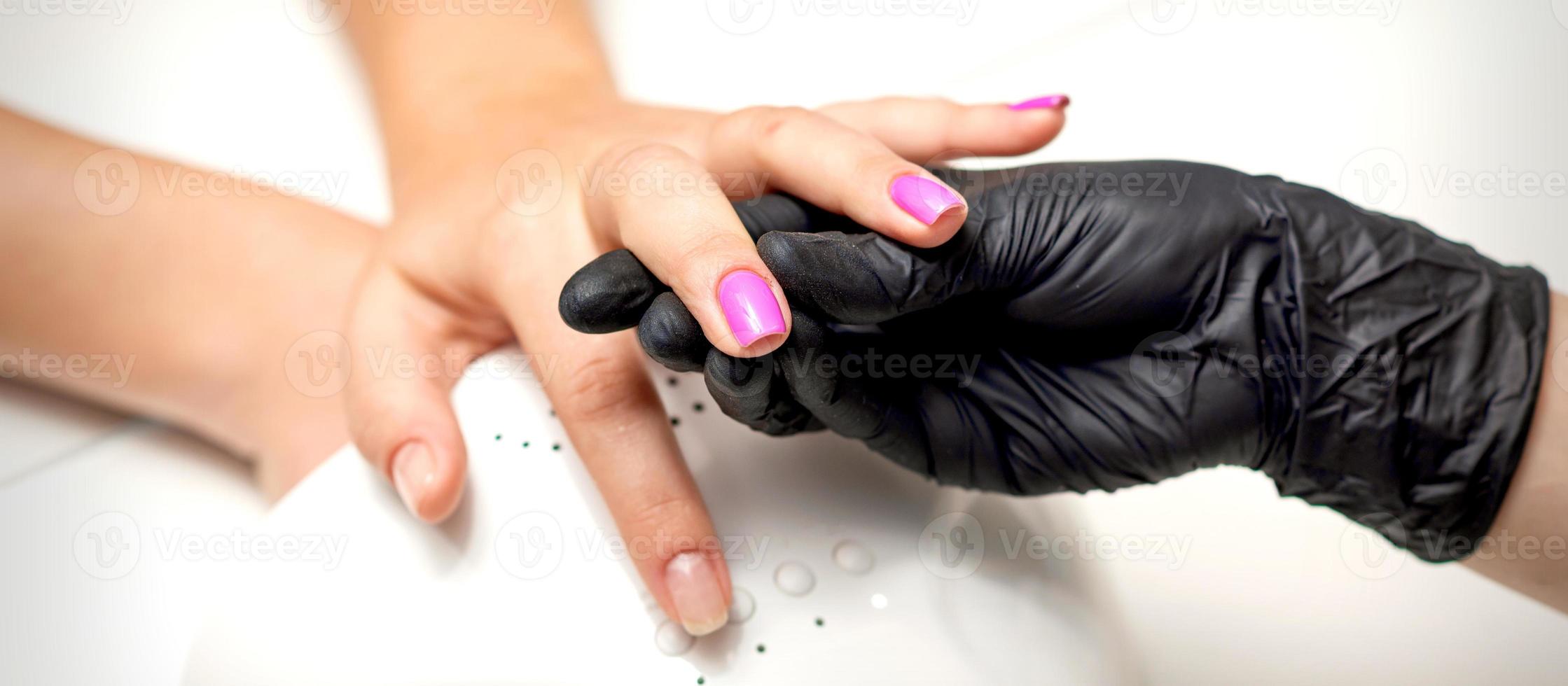 Finger with purple nail polish photo