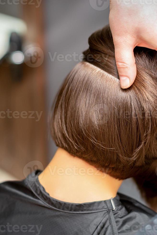 Hairdresser checks short brown hairstyle photo