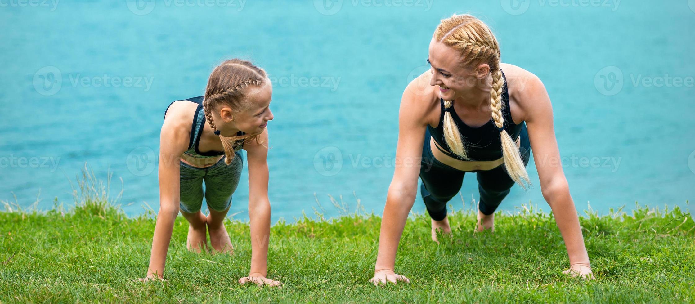 Woman and girl doing push-up exercise photo