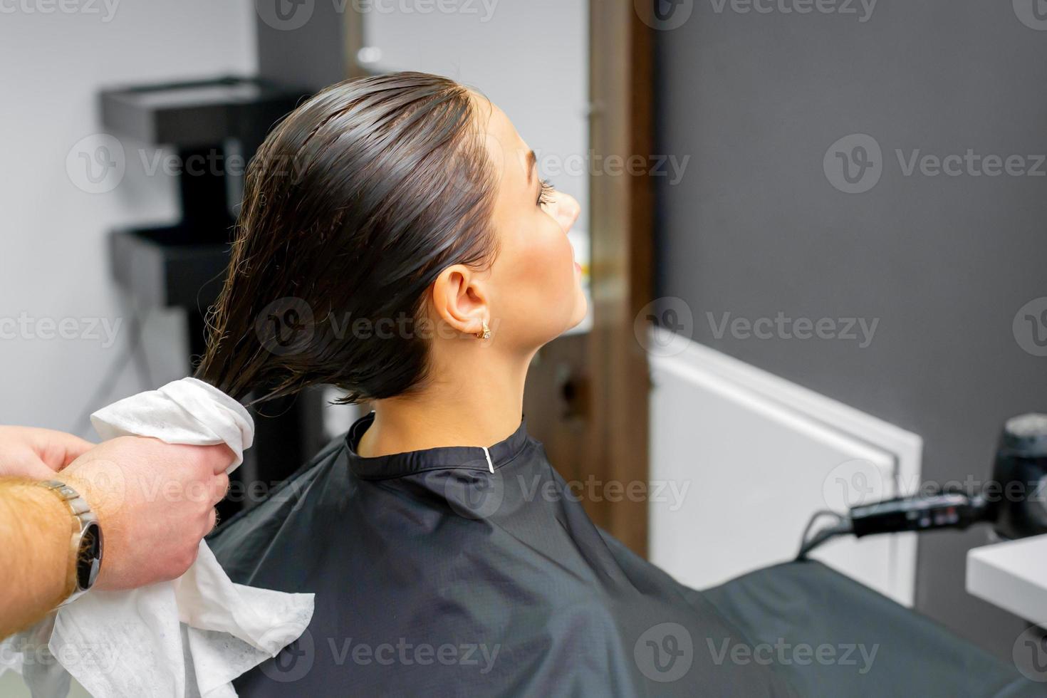 Hairdresser dries the washed hair photo