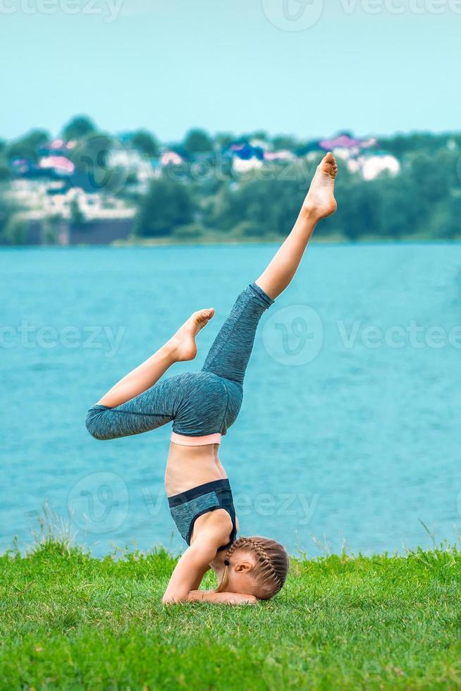 niño haciendo parada de manos ejercicio al aire libre foto