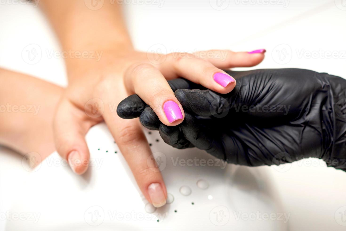 Finger with purple nail polish photo