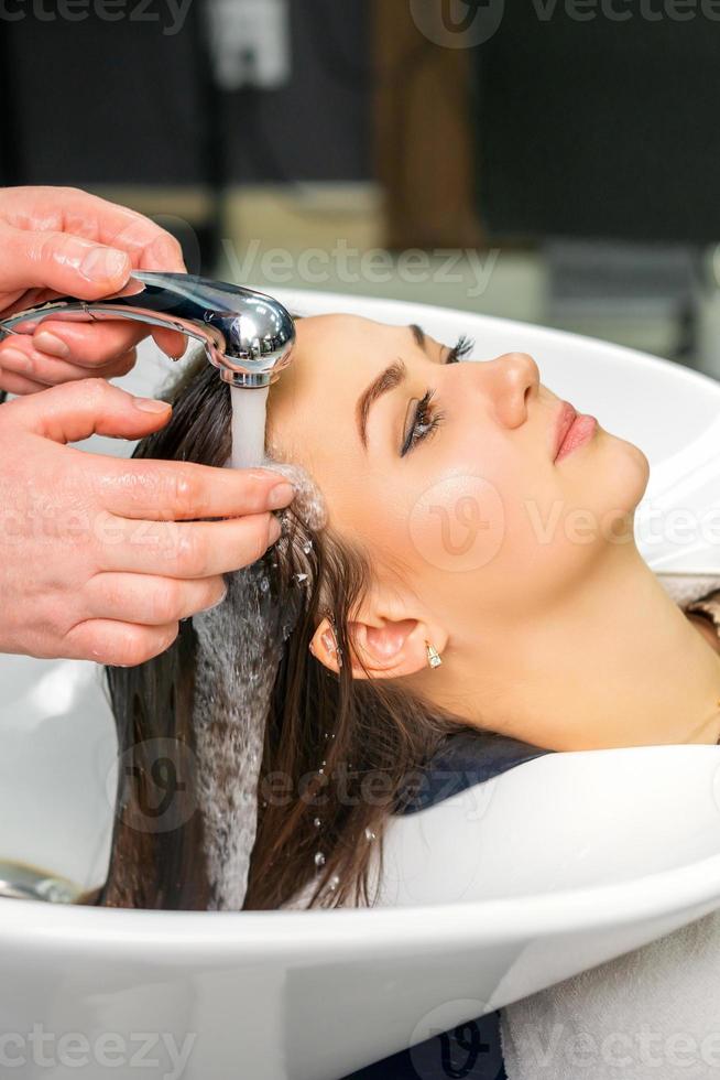 Hairdresser begins to wash hair photo
