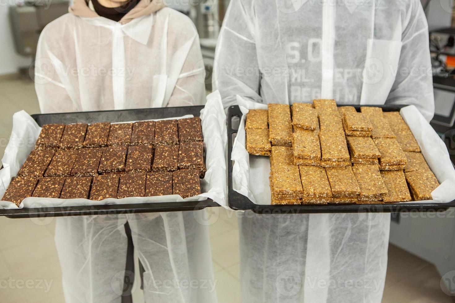 Assortment of cereal or protein bars that leave the assembly line at the factory. Healthy pre or post workout snacks with fruits, nuts and berries. photo