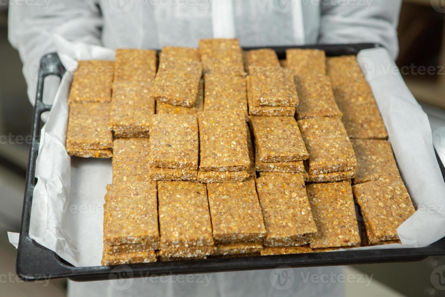 Assortment of cereal or protein bars that leave the assembly line at the factory. Healthy pre or post workout snacks with fruits, nuts and berries. photo