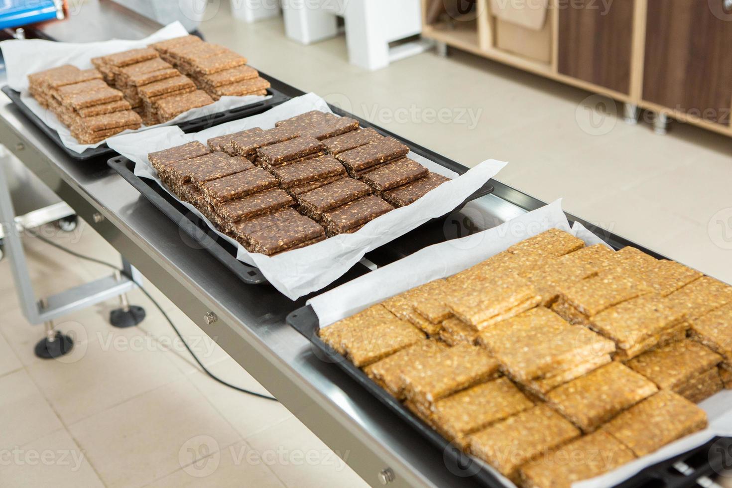 Assortment of cereal or protein bars that leave the assembly line at the factory. Healthy pre or post workout snacks with fruits, nuts and berries. photo