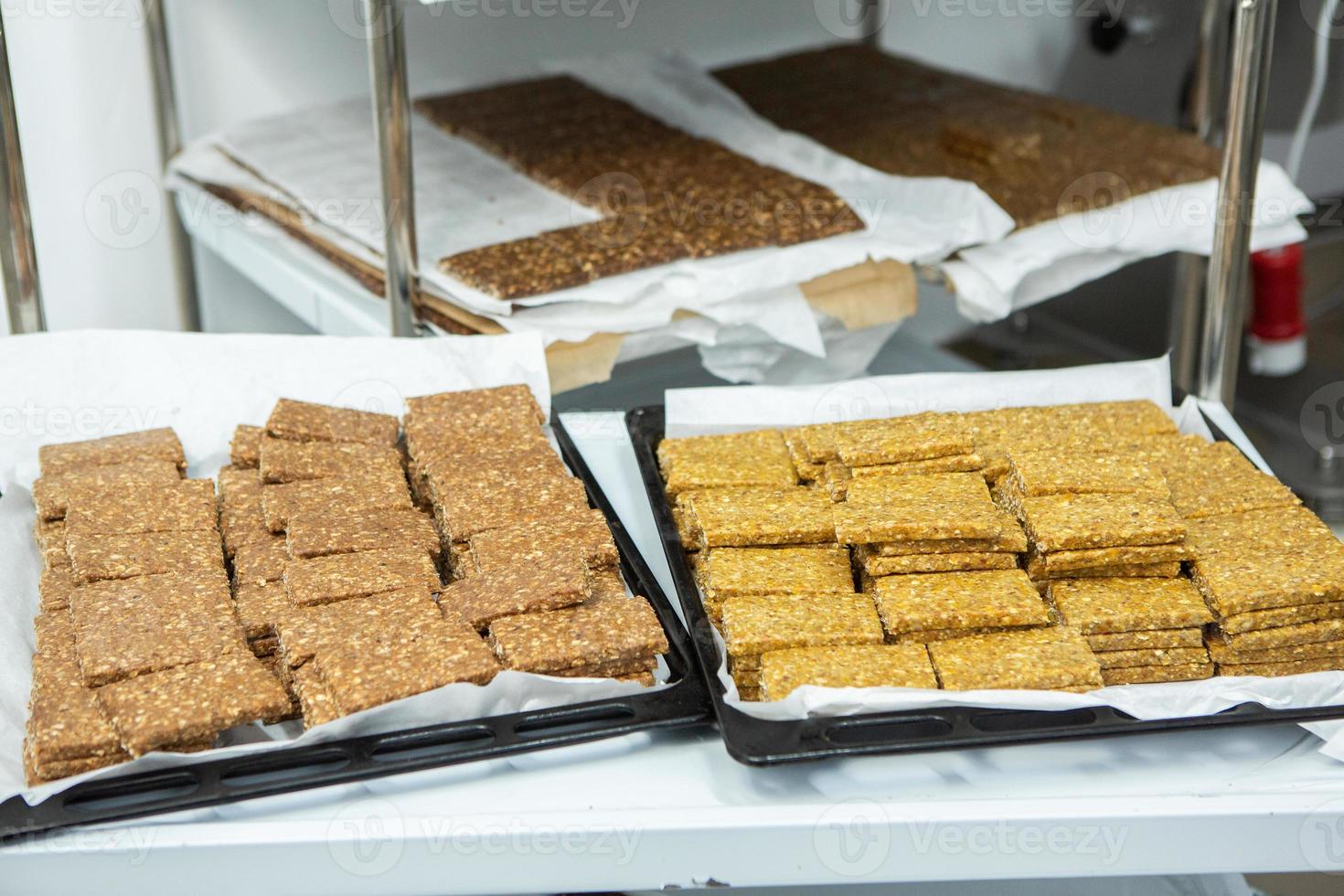 Assortment of cereal or protein bars that leave the assembly line at the factory. Healthy pre or post workout snacks with fruits, nuts and berries. photo