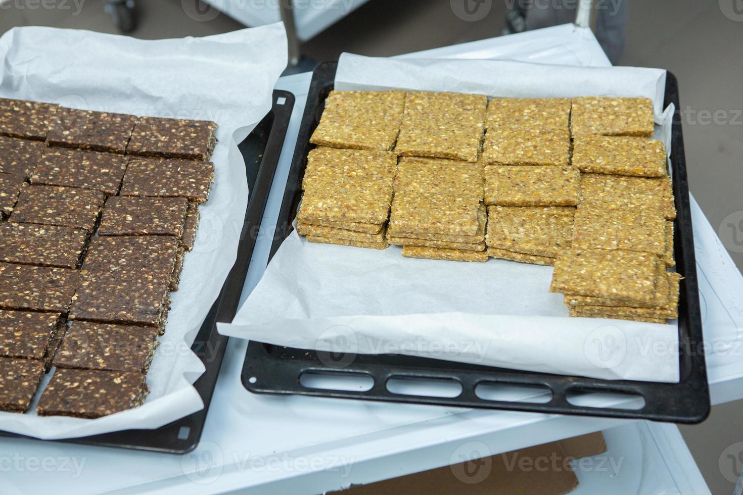 Assortment of cereal or protein bars that leave the assembly line at the factory. Healthy pre or post workout snacks with fruits, nuts and berries. photo