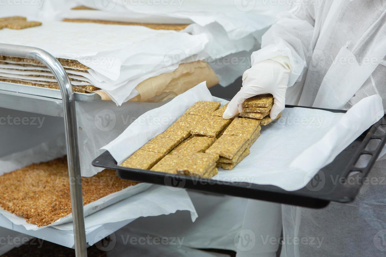 Assortment of cereal or protein bars that leave the assembly line at the factory. Healthy pre or post workout snacks with fruits, nuts and berries. photo