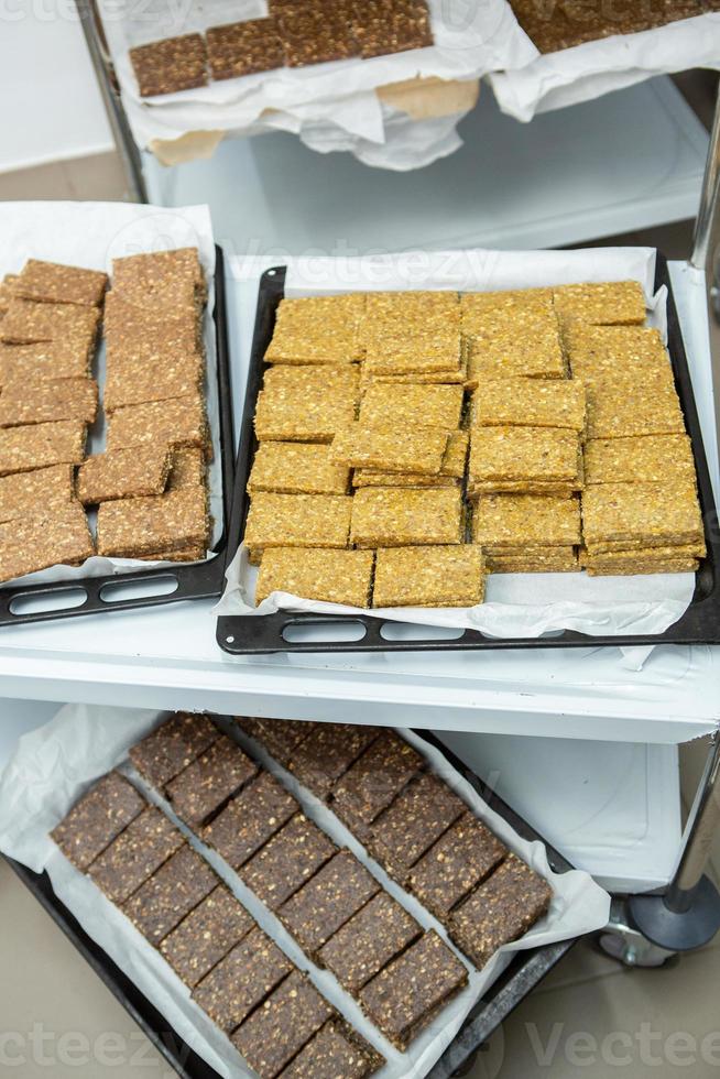 Assortment of cereal or protein bars that leave the assembly line at the factory. Healthy pre or post workout snacks with fruits, nuts and berries. photo