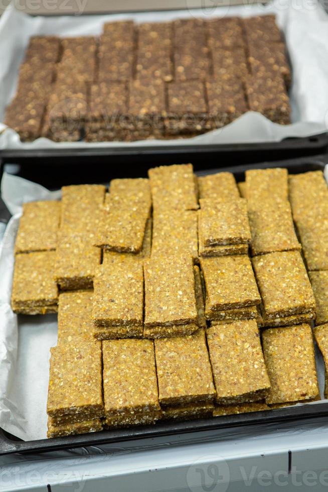 Assortment of cereal or protein bars that leave the assembly line at the factory. Healthy pre or post workout snacks with fruits, nuts and berries. photo