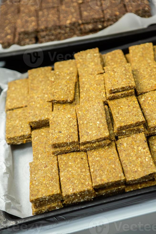 Assortment of cereal or protein bars that leave the assembly line at the factory. Healthy pre or post workout snacks with fruits, nuts and berries. photo