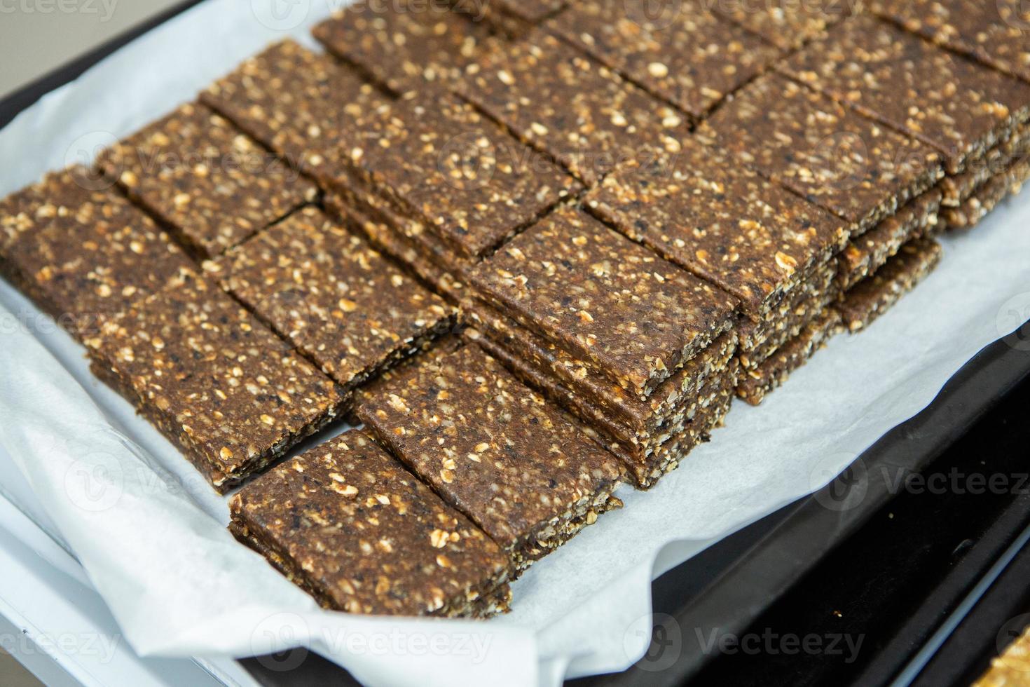 Assortment of cereal or protein bars that leave the assembly line at the factory. Healthy pre or post workout snacks with fruits, nuts and berries. photo