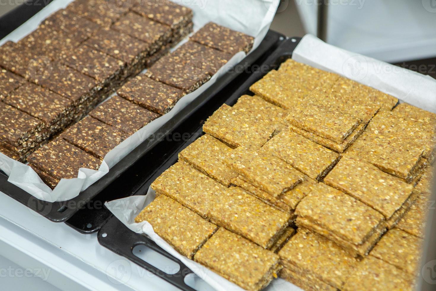 Assortment of cereal or protein bars that leave the assembly line at the factory. Healthy pre or post workout snacks with fruits, nuts and berries. photo