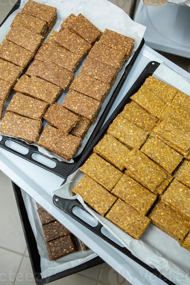 Assortment of cereal or protein bars that leave the assembly line at the factory. Healthy pre or post workout snacks with fruits, nuts and berries. photo