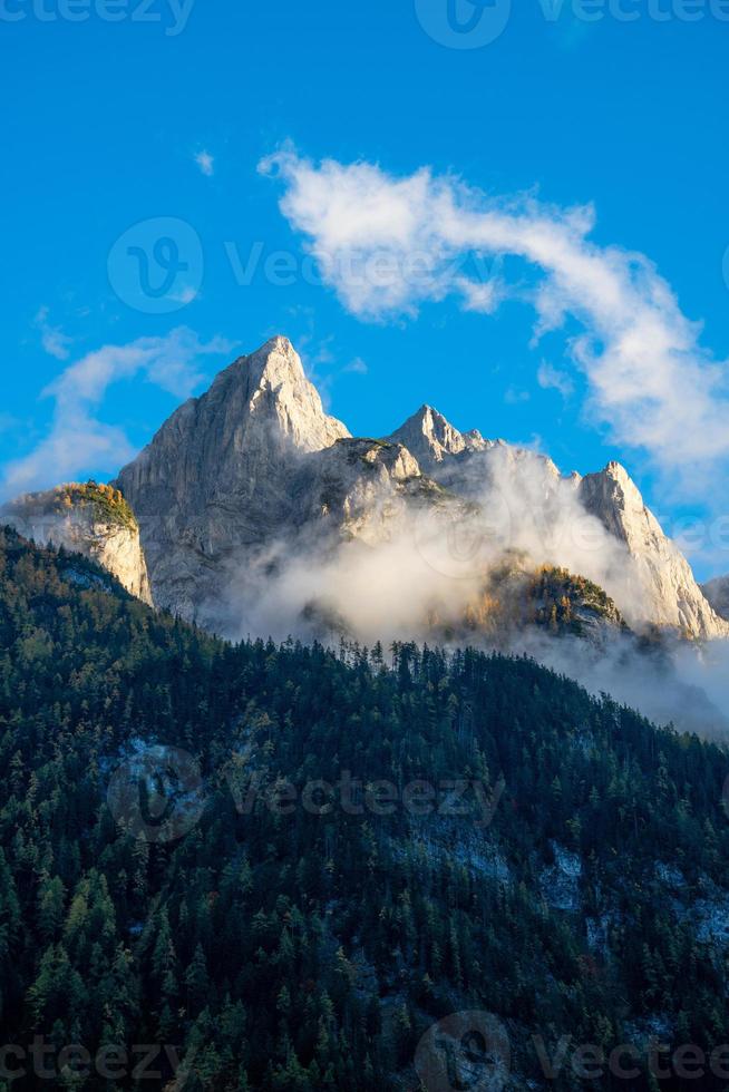 Striking mountain formation under blue sky surrounded by clouds photo