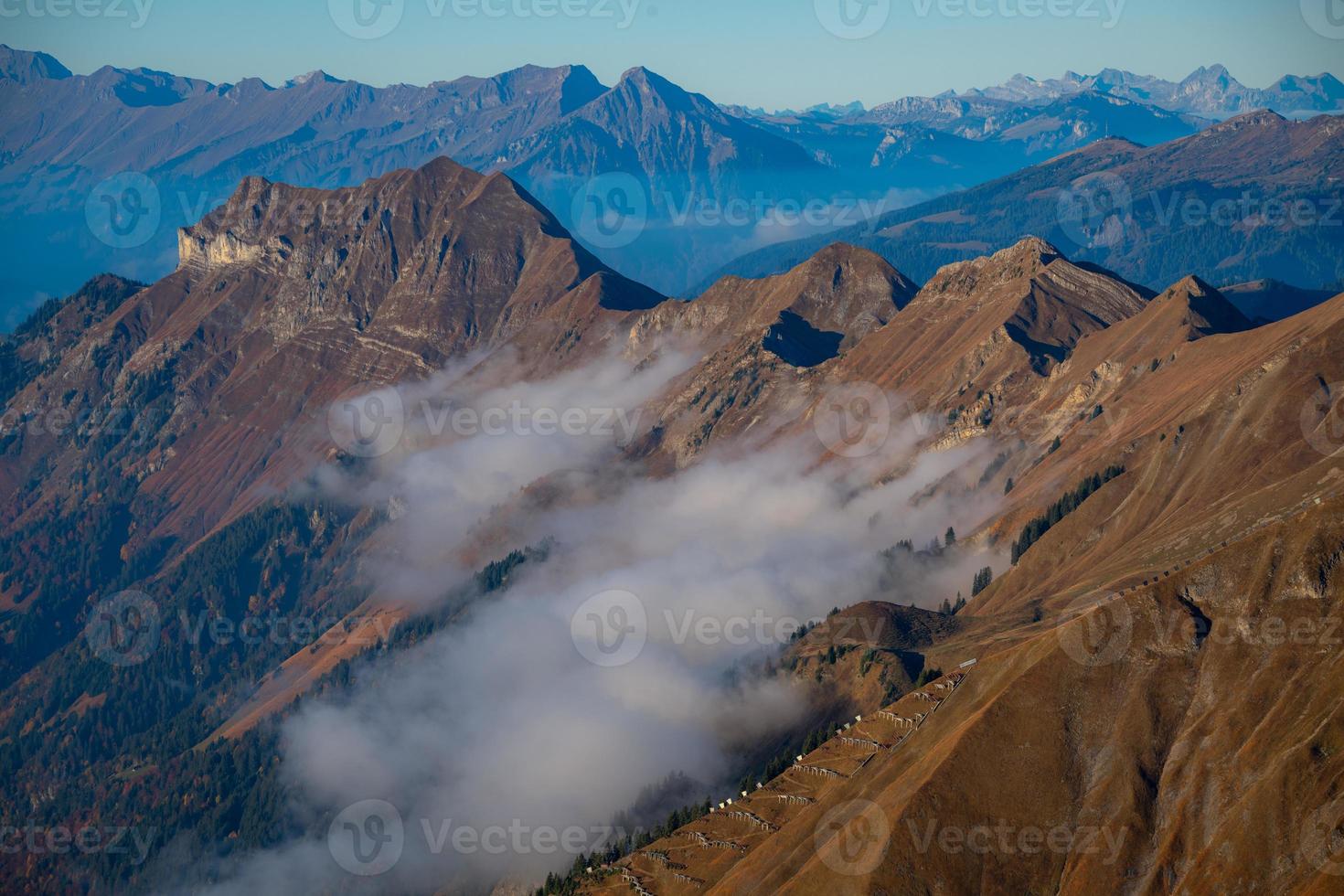 Cold bluish mountain landscape in fog at sunrise photo